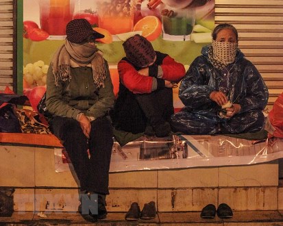 Người lao động co ro trong giá lạnh trên phố Tràng Thi, quận Hoàn Kiếm, đêm 28/12/2018