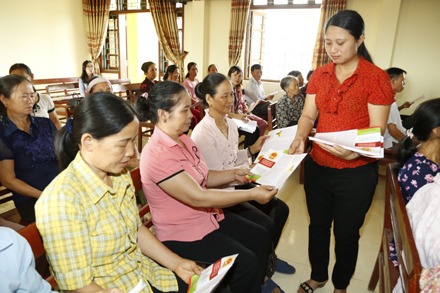 Cán bộ Hội Nông dân tỉnh phát tờ rơi tuyên truyền về sản xuất thực phẩm an toàn tới hội viên xã Mai Sơn.