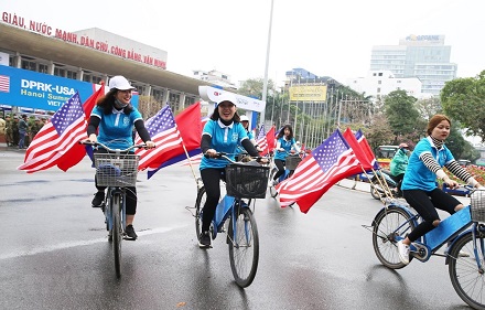 Thiếu nữ Việt Nam diễn hành Đạp xe vì Hòa bình với quốc kỳ Việt Nam và hai nước Mỹ, Triều Tiên trên đường Trần Hưng Đạo, Hoàn Kiếm. (Ảnh: Lâm Khánh/TTXVN)